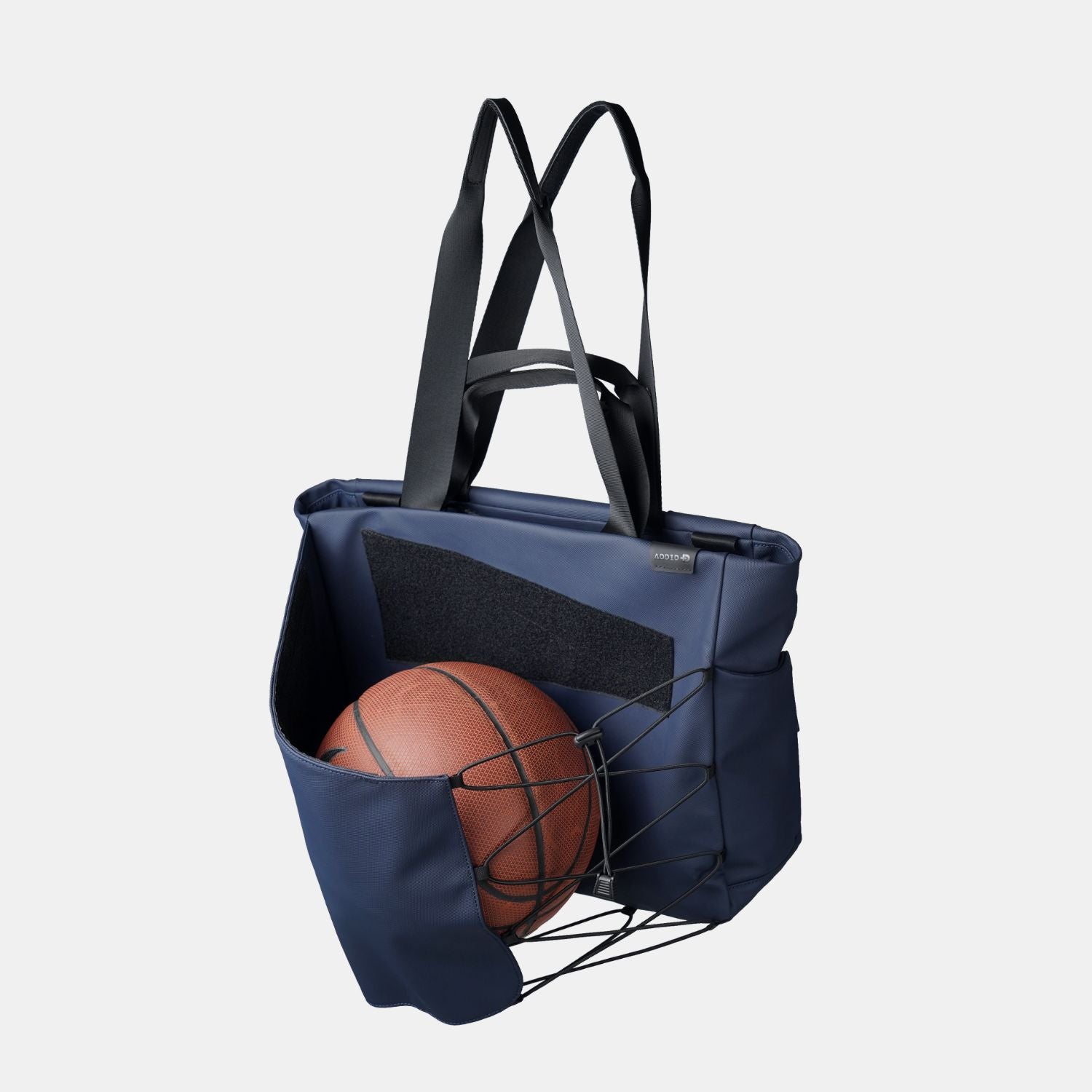 Expandable front Kangaroo pocket on ADD1D Messenger Tote stowing a jacket and water bottle