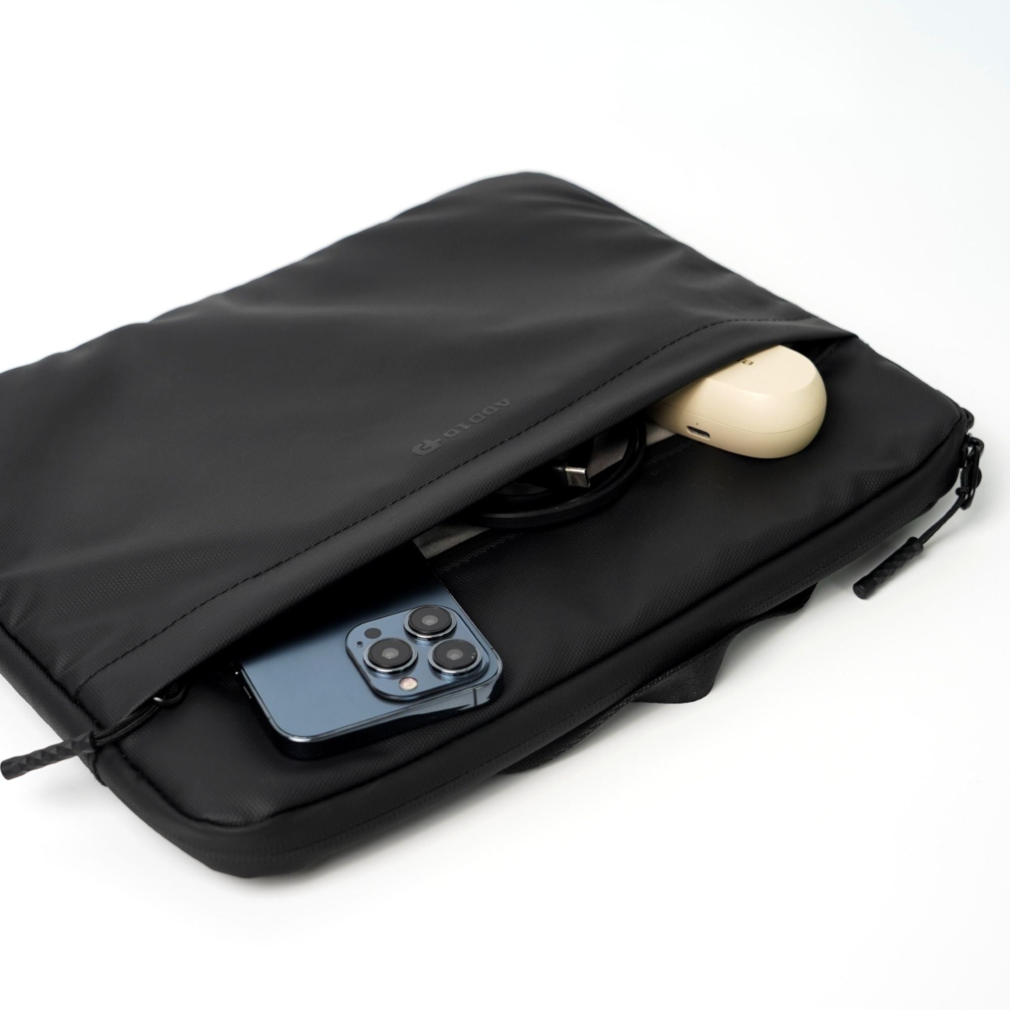 Front zipper pocket on ADD1D Tablet Sleeve organized with Apple Pencil, cables, and charger